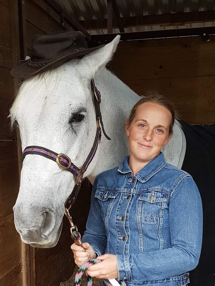 Tara Kemp with her horse, Bella, in a stable.